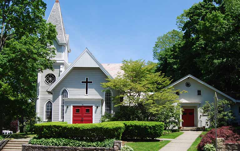 A church with two red doors and a white cross.